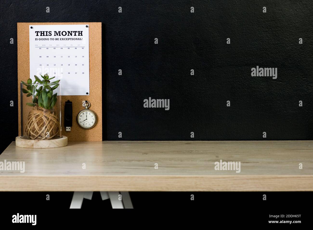Dieses Heimbüro hat eine Kork-Tafel mit einem Kalender, Vintage-Taschenuhr, und USB-Flash-Laufwerk, um es fixiert. Der Schreibtisch ist organisiert und ordentlich. Stockfoto