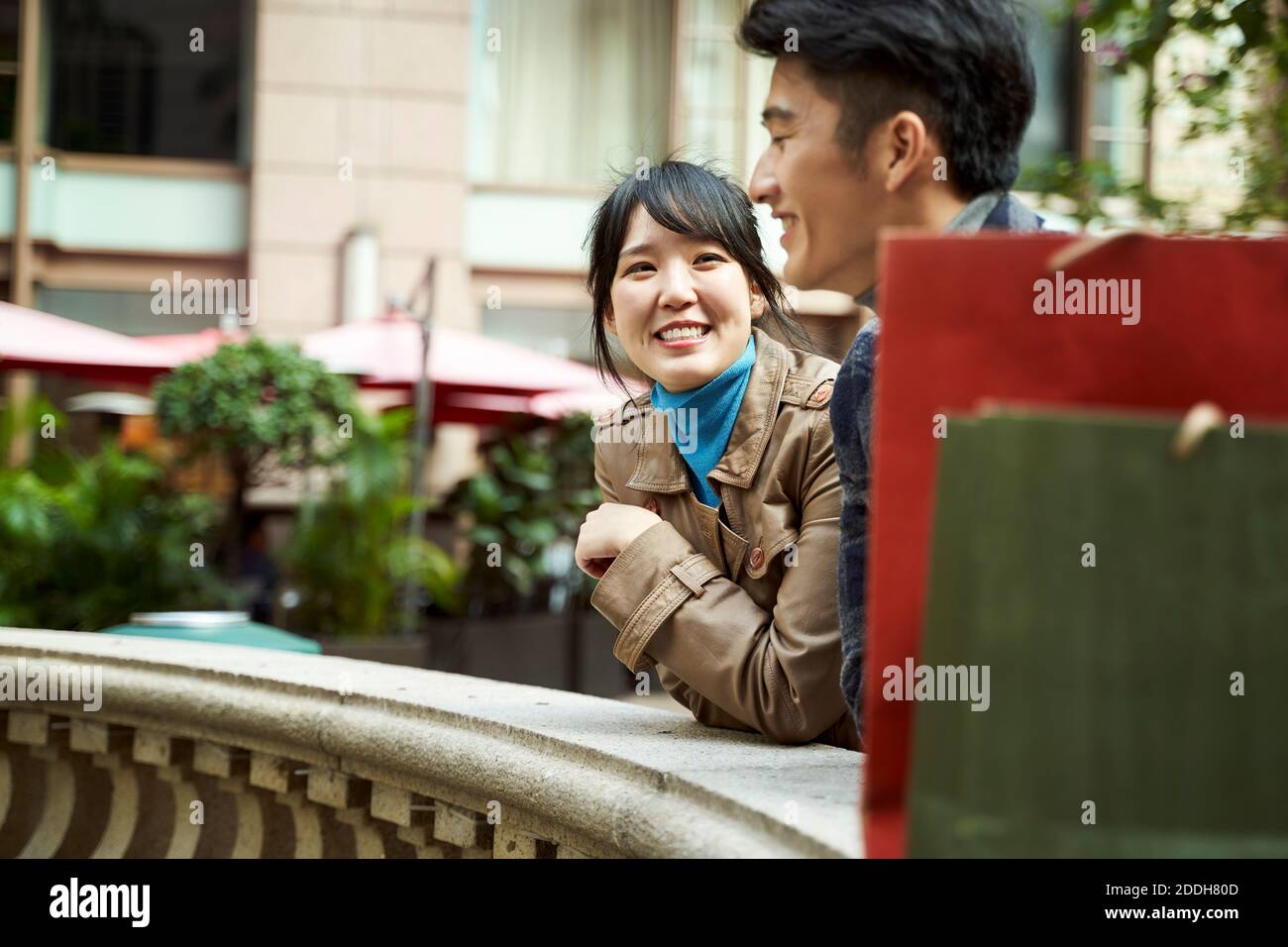 Glücklich junge asiatische paar entspannen im Freien chatten Stockfoto