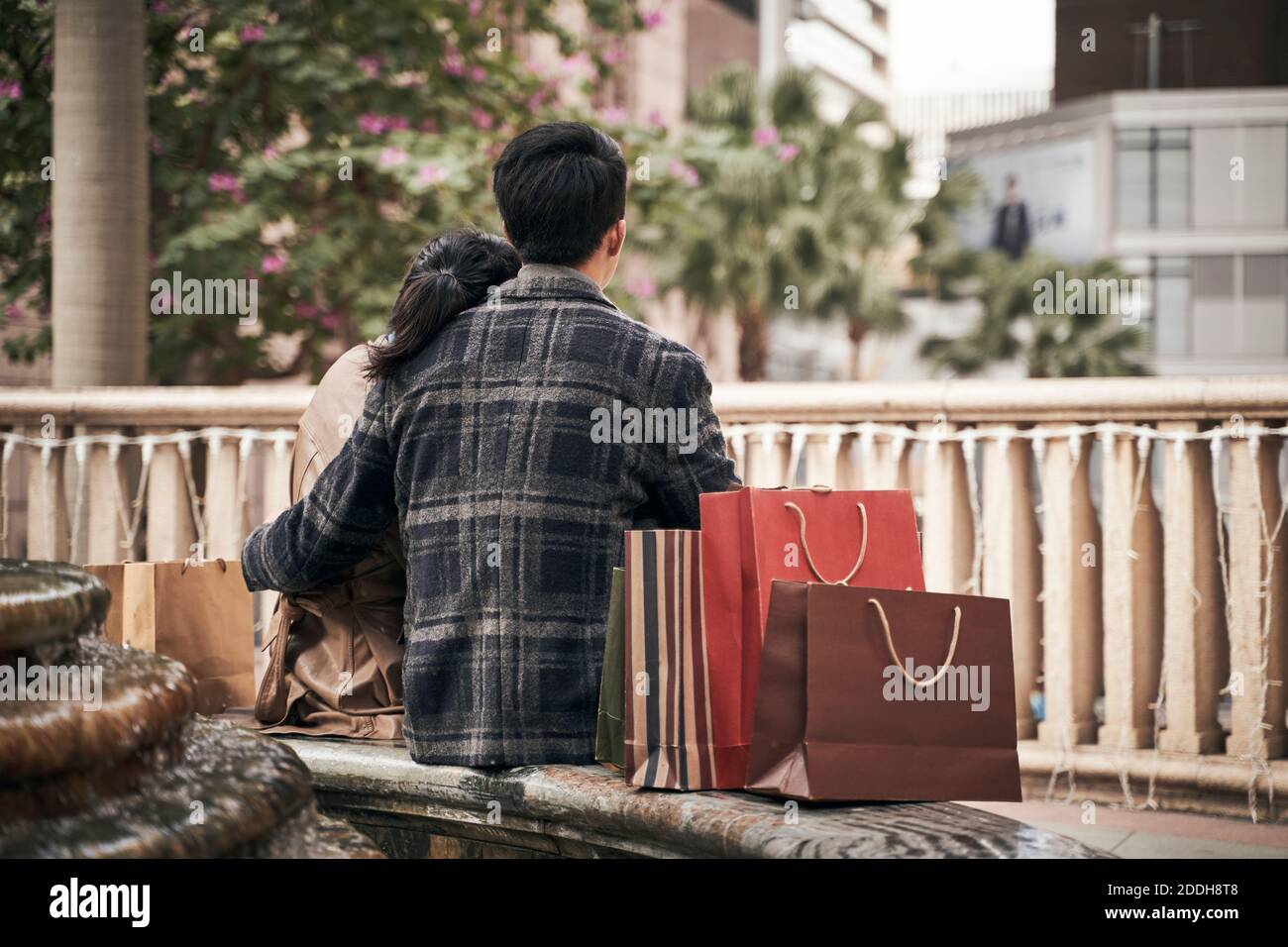 Rückansicht der jungen asiatischen Paar entspannen im Freien, während Einkaufen in der Stadt Stockfoto