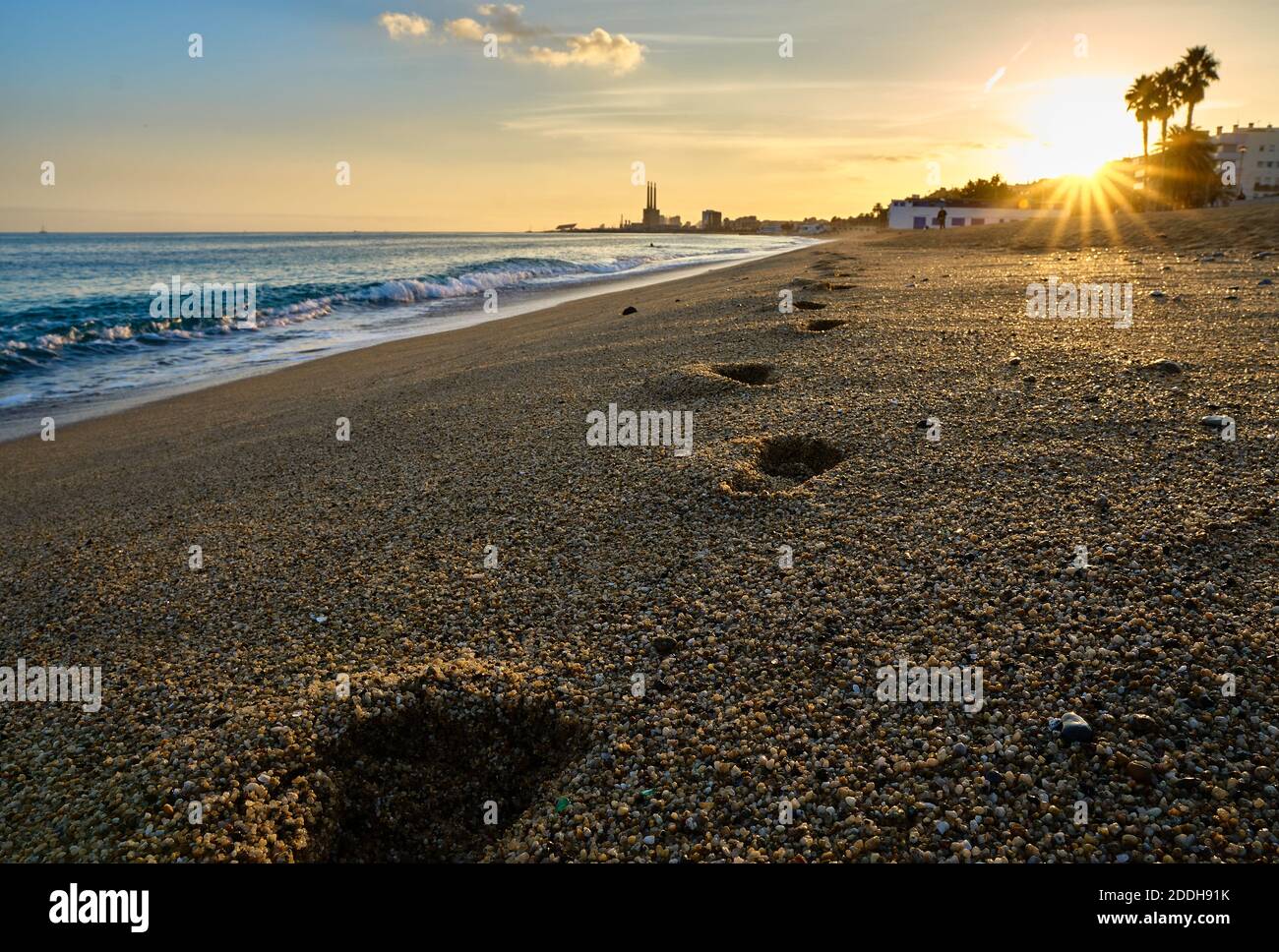 Konzentrieren Sie sich auf den zweiten Schritt am Strand bei Sonnenuntergang Zeit in Badalona Spanien mit einem Ausbleichen der Landschaft Im Hintergrund Stockfoto