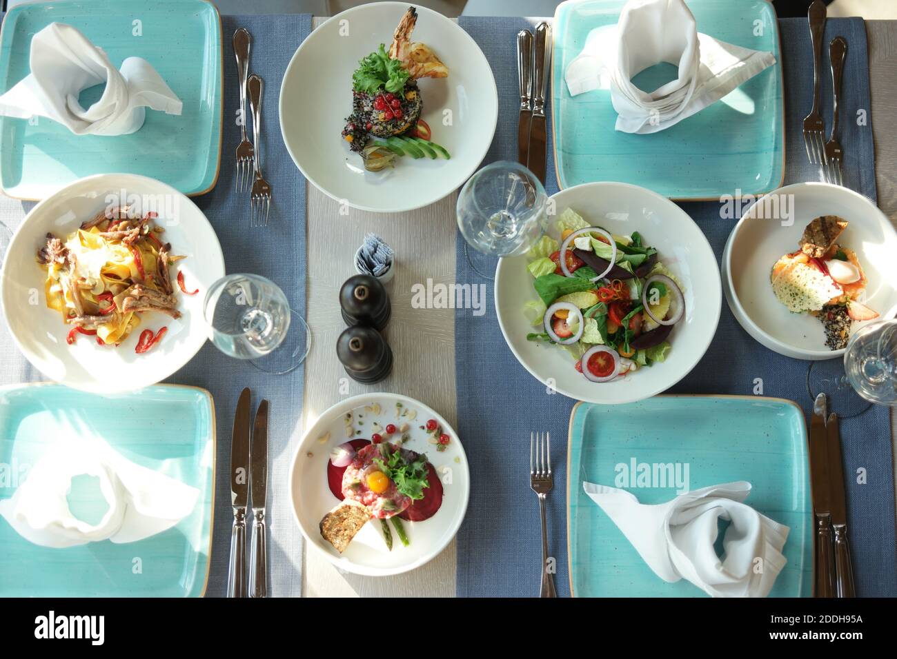 Mittagessen im Restaurant. Blick von oben auf leckere Gerichte sind auf dem Tisch. Wunderschön servierter Tisch für vier Personen in einem Restaurant. Stockfoto