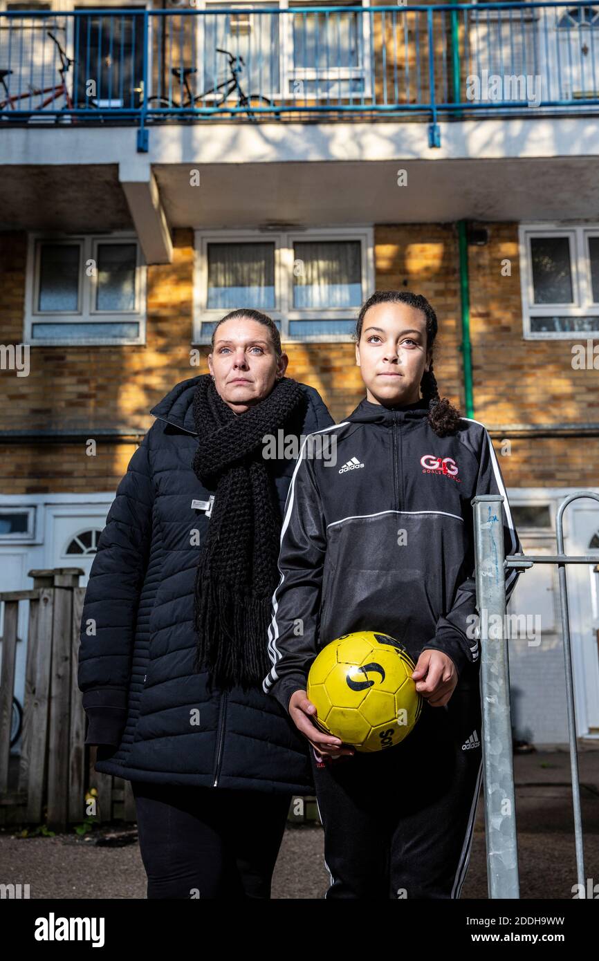 Teenager Mädchen außerhalb ihres Hauses nach der Schule Fußball spielen, nachdem eine nationale Coronavirus Lockdown gestoppt sie für ihre Samstag Fußballmannschaft spielen. Stockfoto