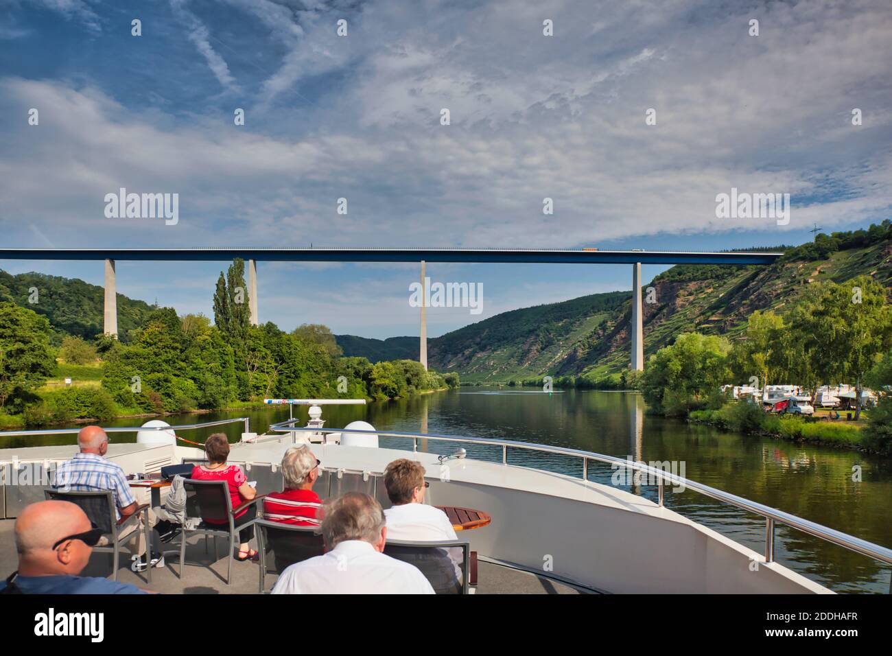 Eine Gruppe von Passagieren auf einem Kreuzfahrtschiff auf dem Rhein in Deutschland, beobachten die Landschaft vorbeiziehen, während sie unter einer Straßenbrücke vor sich gehen Stockfoto