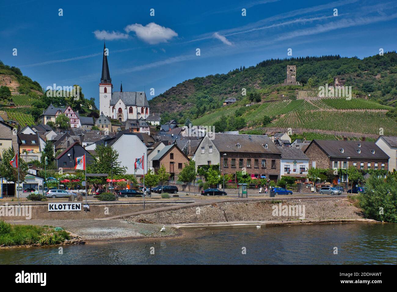 Ein Stadtbild vom Rhein aus gesehen, mit Gebäuden aller Größen und einer weißen Kirche mit Turm hoch auf einem Hügel im Hintergrund Stockfoto
