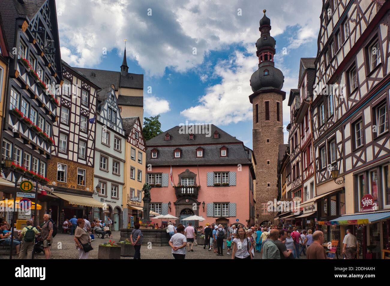 Ein geschäftiges Stadtplatz in Cochem mit Menschen mit Häusern, Ladenfronten und Kirchturm, Cochem am Rhein, Deutschland gedrängt Stockfoto