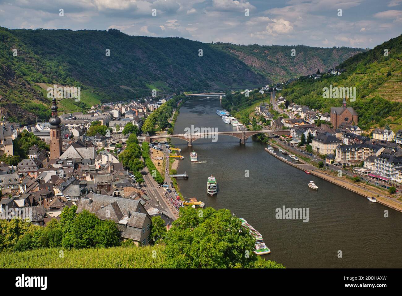 Ein Blick auf den Rhein mit Booten, wo er durch Cochem, Deutschland, mit Brücken und Gebäuden passiert Stockfoto