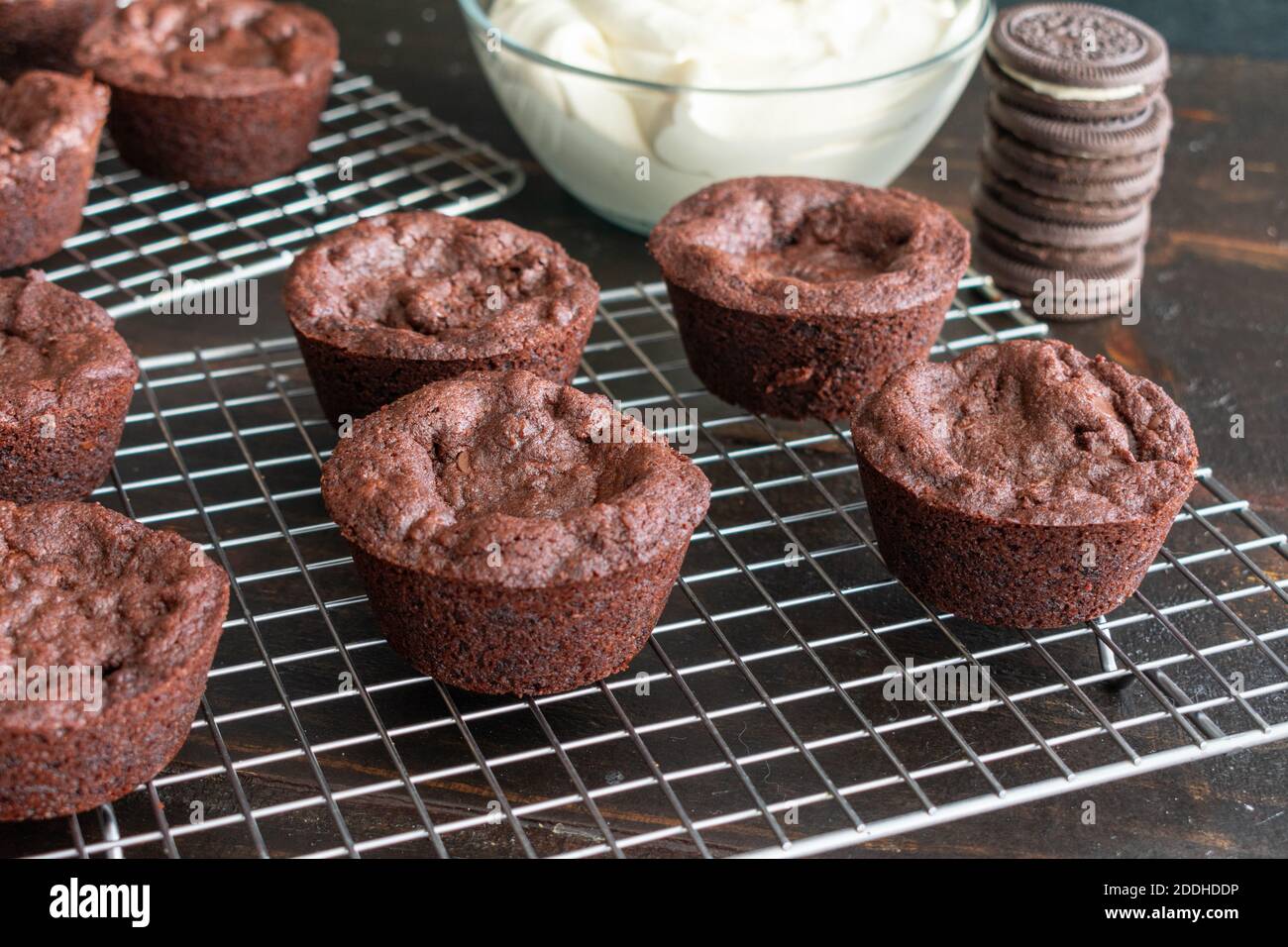Oreo gefüllte Brownie Cups: Brownie Tassen gefüllt mit einem Sandwich-Cookie und gekrönt mit Zuckerguss auf einem Draht Kühlgestell Stockfoto