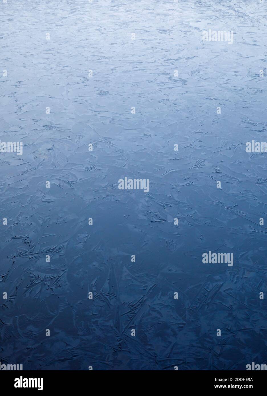 Nahaufnahme des ersten Eisabrutschens auf der Wasseroberfläche des Sees im Winter in Finnland Stockfoto
