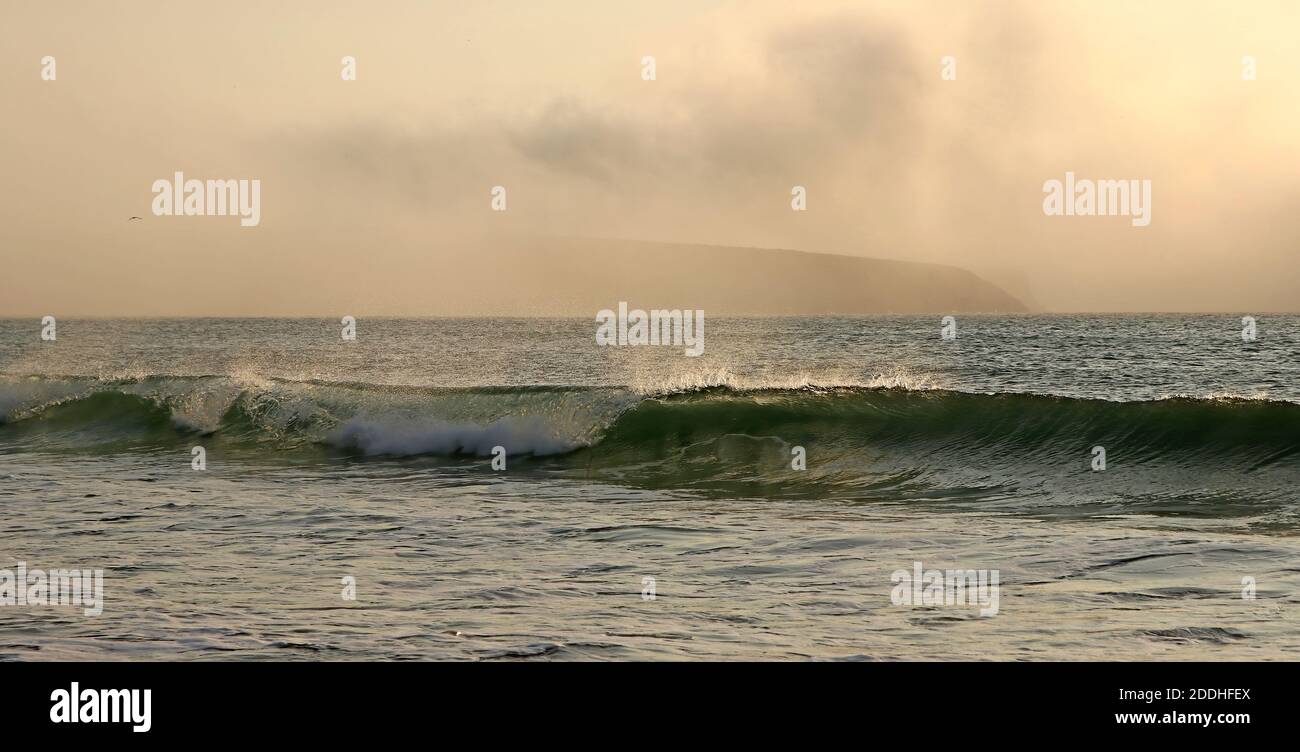Brechende Welle rollt in den Strand im Abendlicht, genau richtig für eine Brandung, da die Welle Tubing ist Stockfoto