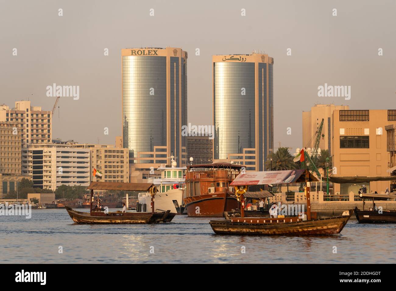 Dubai, VAE - 1. September 2020: Zwei Abra, das traditionelle hölzerne Fährschiff, segeln auf dem Creek mit dem Rolex Twin Tower im Hintergrund im Bur D Stockfoto