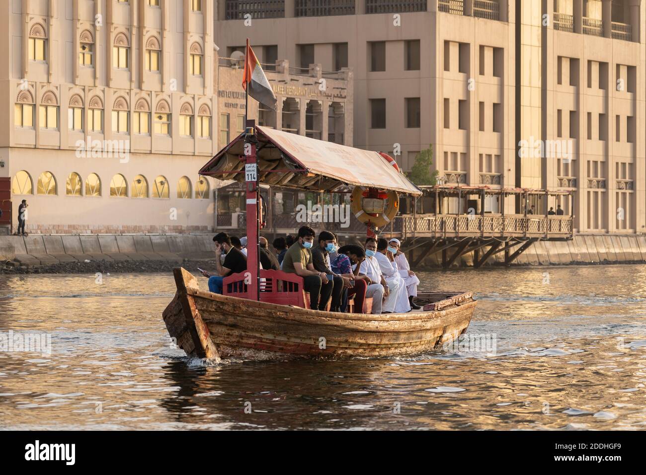 Dubai, VAE - 1. September 2020: Einheimische, die wegen Covid Pandemia eine Gesichtsmaske tragen, reisen mit einer Abra, der traditionellen Holzfähre auf dem Creek in Stockfoto