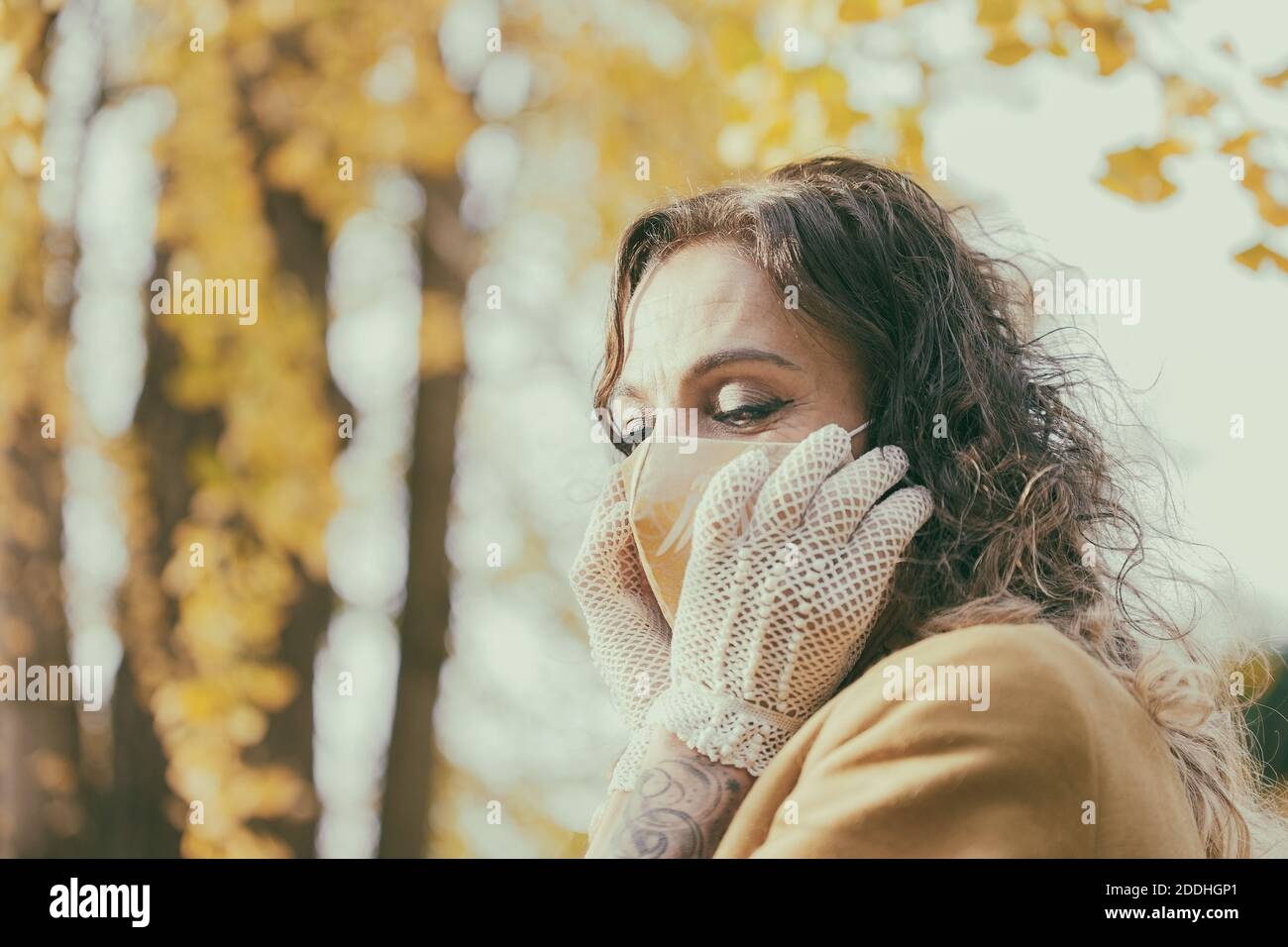 Frau mit Handschuhen, die ihre Maske berührt, spanien Stockfoto