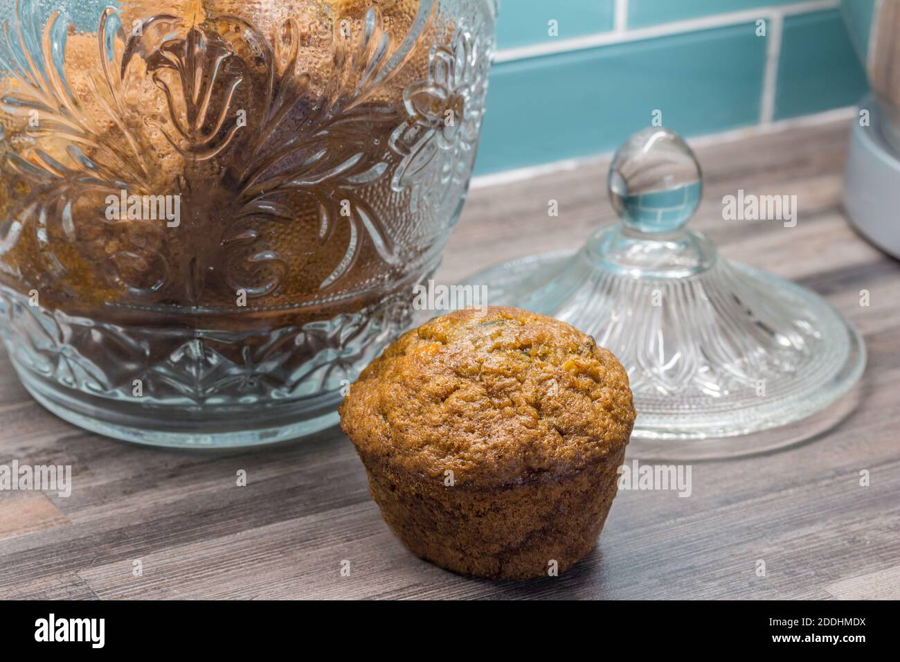Karotte, Apfel, Zimt, Kürbiskernmuffin auf Küchenarbeitsplatte neben Glas mit Muffins Stockfoto