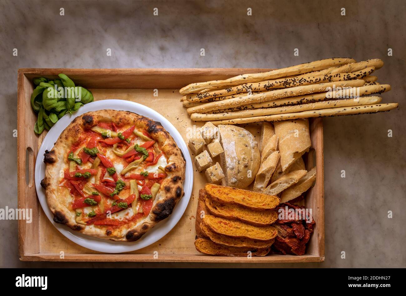 Pizza mit Paprika und Arten von Brot und Brot Sticks in rustikalen Holztablett. Lebensmittel, die reich an Kohlenhydraten. Draufsicht Stockfoto