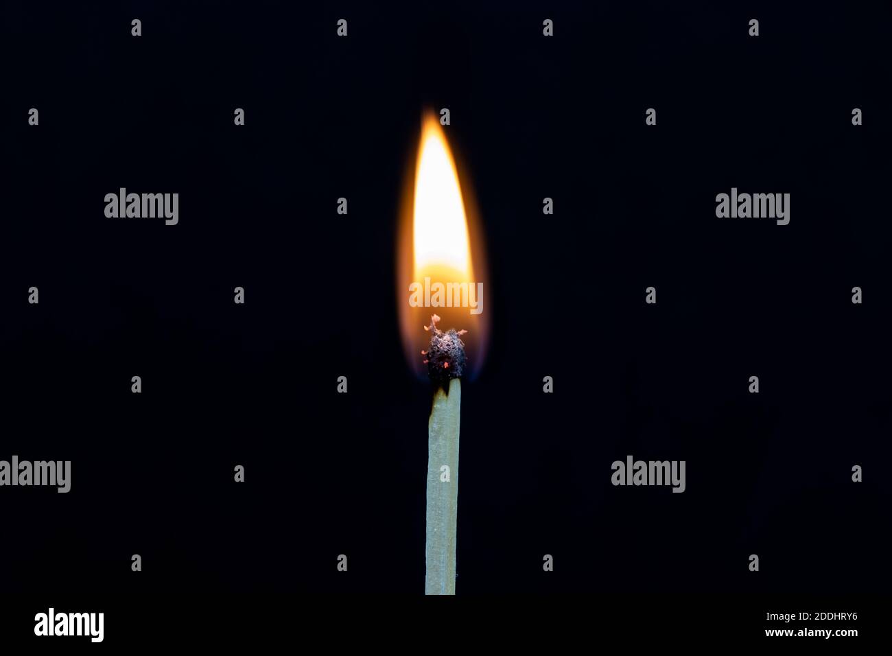 Einzelner Streichholzstock auf Feuer isoliert auf schwarzem Hintergrund Stockfoto