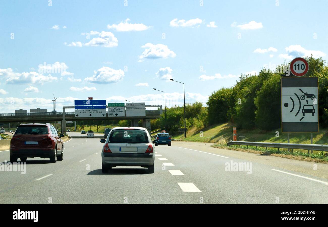 Fahren auf einer Autobahn, mit einem Schild, das eine Radarkontrolle für die Geschwindigkeitsbegrenzung anzeigt. Stockfoto