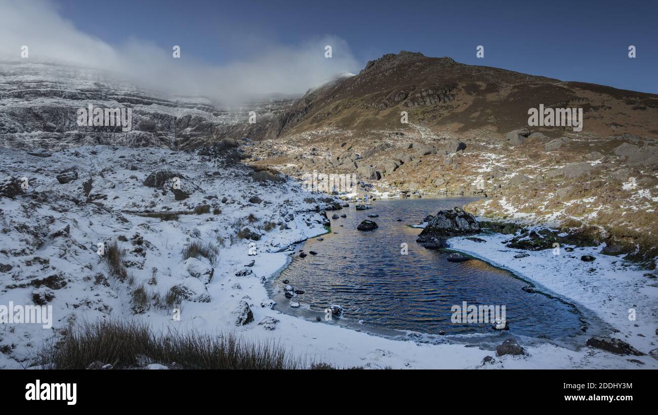 Ein gefrorener Fluss in einer verschneiten Schlucht im Winter Stockfoto