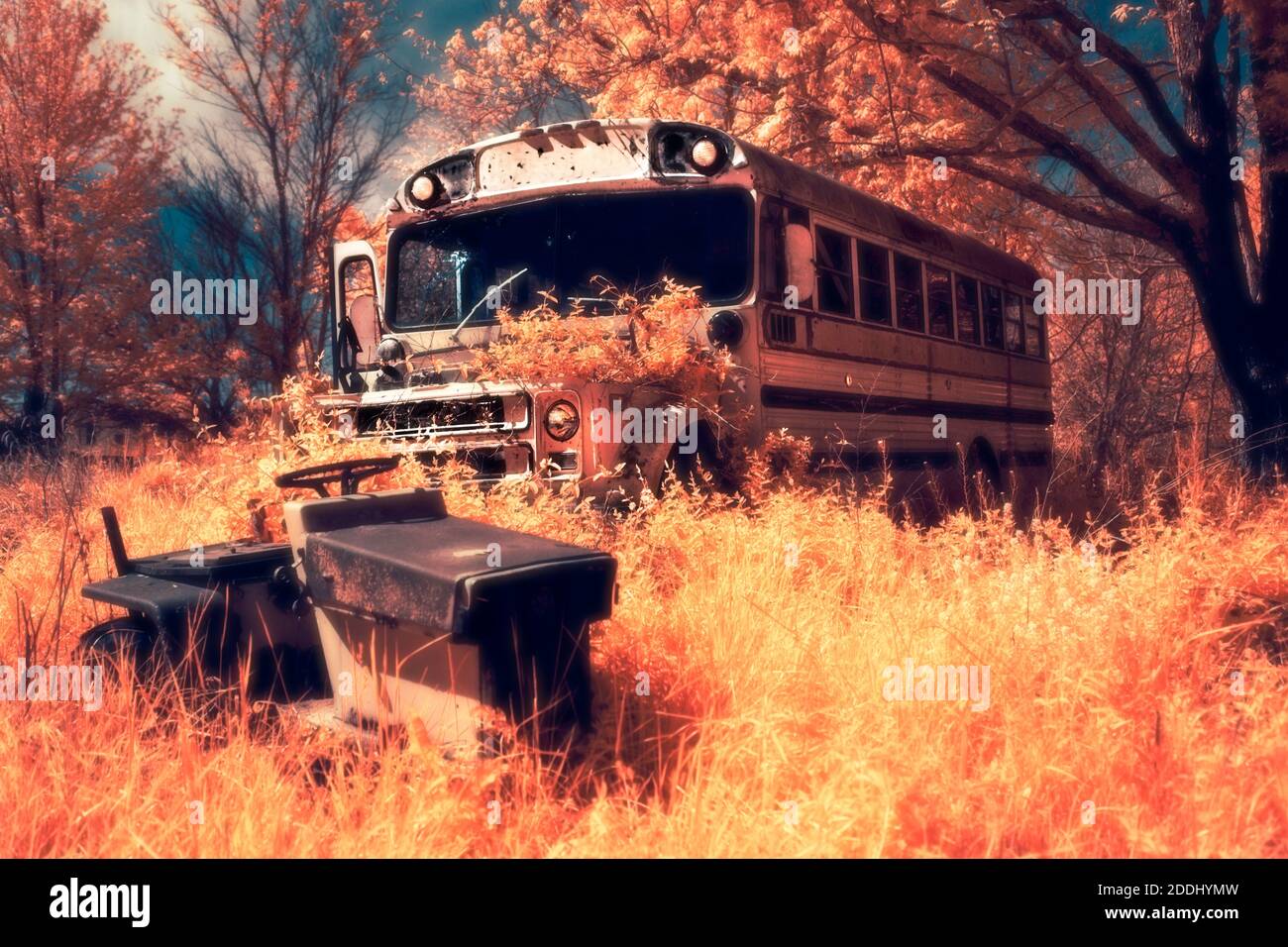 Ein Schulbus und ein Rasenmäher rosten in einem vergessenen Grundstück in Little York, IN. Aufgenommen in 590 nm IR-gefiltertem Licht. Stockfoto