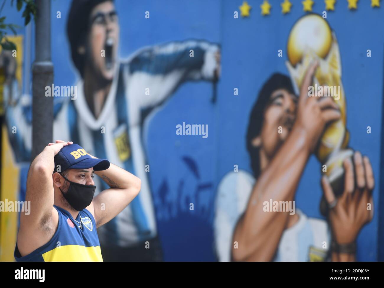 Buenos Aires, Argentinien. November 2020. Ein Fan des Boca Juniors Fußballclubs trauert vor dem Stadion La Bombonera im Viertel La Boca, wo Wandmalereien von Fußballstar Diego Maradona zu sehen sind. Die argentinische Fußballlegende starb im Alter von 60 Jahren. Kredit: Fernando Gens/dpa/Alamy Live Nachrichten Stockfoto