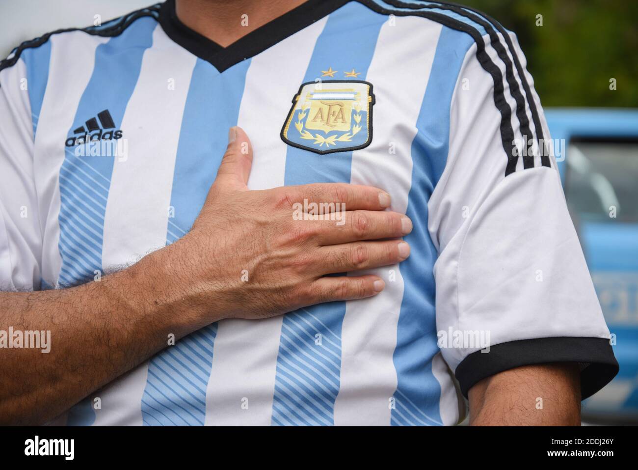 Buenos Aires, Argentinien. November 2020. Ein Mann, der ein Trikot der argentinischen Nationalmannschaft trägt und vor dem Haus steht, in dem Diego Maradona starb, legt seine Hand auf sein Herz, während er trauert. Die argentinische Fußballlegende starb im Alter von 60 Jahren. Kredit: Julieta Ferrario/dpa/Alamy Live Nachrichten Stockfoto