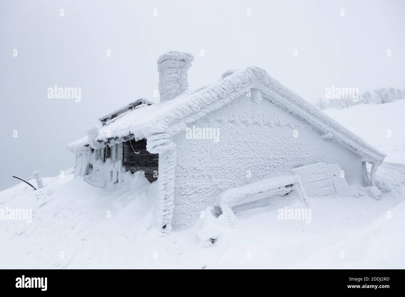 Winterpanorama-Landschaft mit Hütte unter Schnee, Nebel. Winter Hintergrund von Schnee und Frost.malerische und wunderschöne Winterszene.Amazing Bergvie Stockfoto
