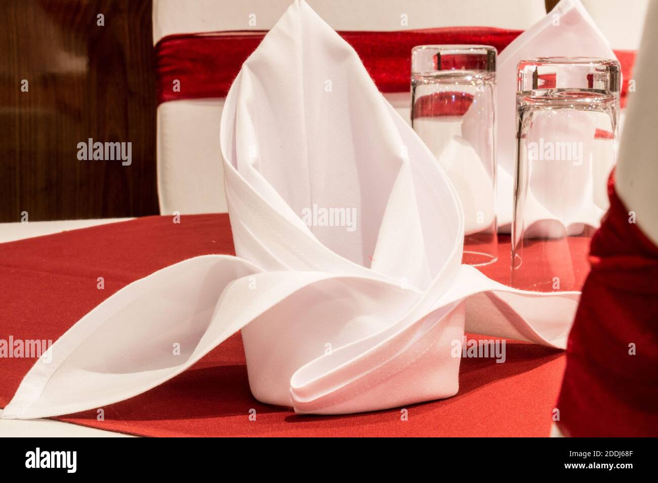 Esstisch mit Wasserglas und weißer Serviette Stockfoto
