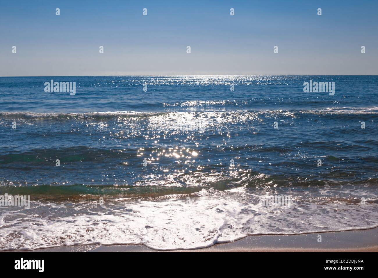 Im blauen Meer mit einer Welle funkelt die helle Sonne. Stockfoto