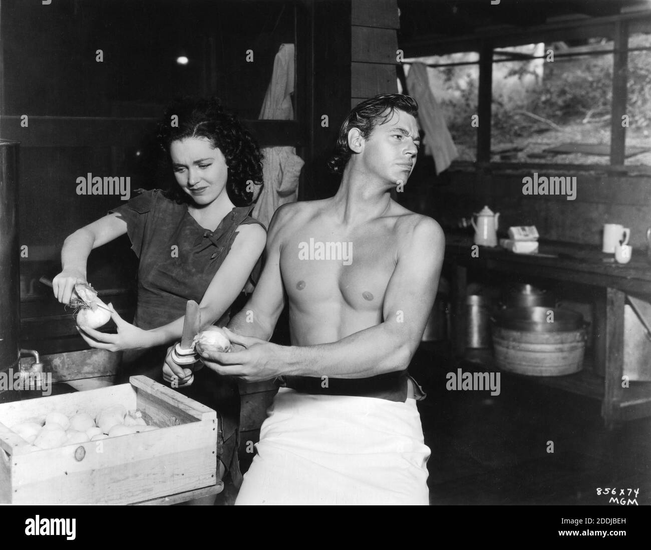 MAUREEN O'SULLIVAN und JOHNNY WEISSMULLER am Set Publicity Gag gedreht in der Lagerküche Zwiebel schälen während Drehort Dreharbeiten von TARZAN ESCAPE aka DIE GEFANGENNAHME VON TARZAN 1936 Regisseure RICHARD THORPE JOHN FARROW JAMES C. McKay GEORGE B. SEITZ WILLIAM A. WELLMAN Drehbuch Cyril Hume nach Figuren von geschaffen Edgar Rice Burroughs Metro Goldwyn Mayer Stockfoto