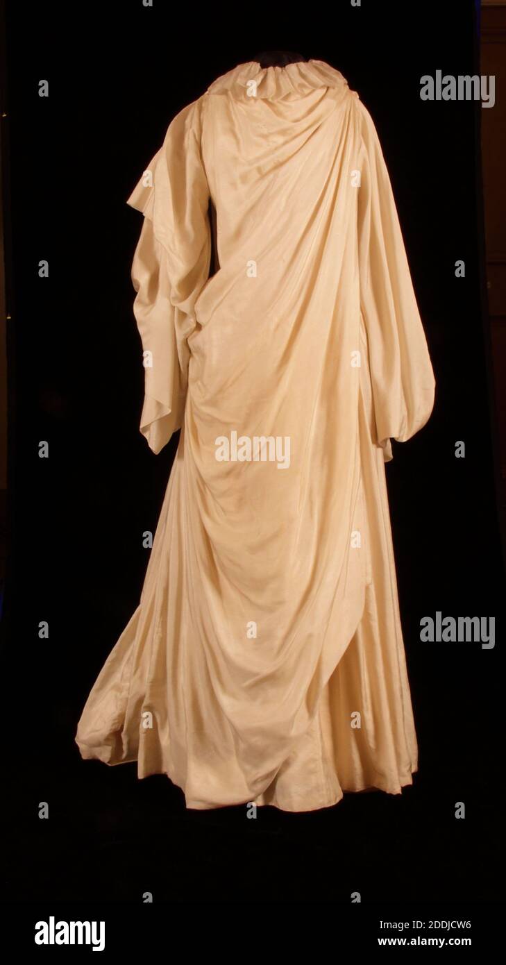 Hochzeitskleid aus Seide, 1891 von Liberty & Co. Elfenbein Pongee SeidenHochzeitskleid. Hoher Hals mit breiter Rüsche. Ein Tuch aus Stoff von der rechten Seite der Taille bis zur linken Schulter verbirgt den vorderen Verschluss. Lange, eng angeschnittene Ärmel. Die Rückseite des Kleides hat eine eng anliegendem Oberteil. Drapierte Panel fallen von beiden Schultern in eine Schleppe, die mit einem tiefen Spitzen Rüschen getrimmt ist Stockfoto