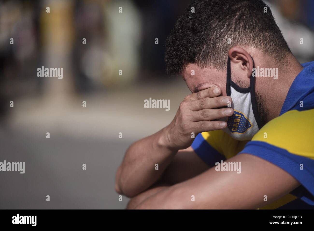 Buenos Aires, Argentinien. November 2020. Ein Fan mit Trikot und Maske in den Farben des Boca Juniors Fußballvereins weint vor dem La Bombonera Stadion nach dem Tod von Fußballstar Diego Maradona. Die Fußballlegende spielte in Boca Juniors in den 80ern und dann wieder in den 90ern. Kredit: Fernando Gens/dpa/Alamy Live Nachrichten Stockfoto