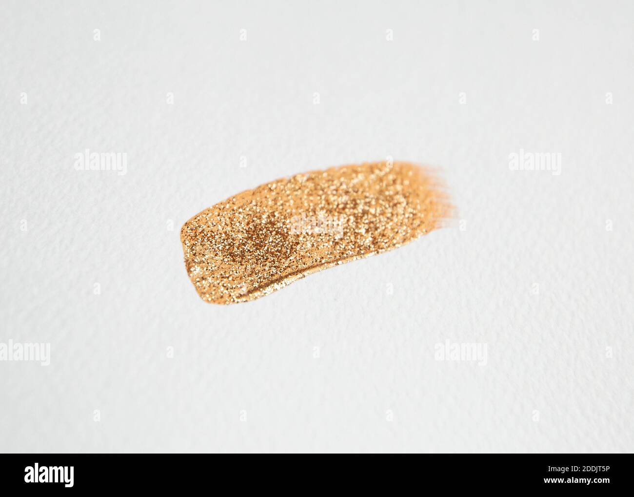 Goldfarbe mit Glitzer auf weißem Aquarellpapier abschmieren. ... Goldene Farbe Stockfoto