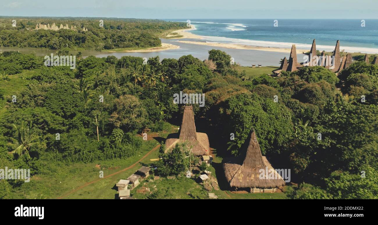 Indonesien lange Tradition Dorf mit verzierten Dach am Sandstrand Luftaufnahme. Außergewöhnliche Häuser, Bienenstöcke im grünen Tal mit tropischem Wald. Erstaunliche Naturlandschaft der Sumba Insel, Asien Stockfoto