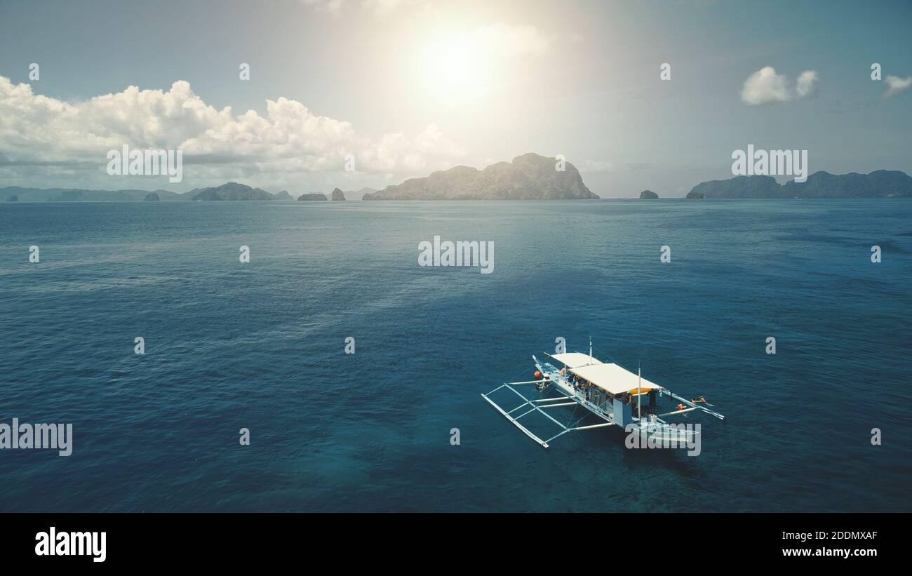 Sonne Sandstrand mit Booten auf Meerwasser. Tour auf Schiffen am Hafen mit Sandstrand. Grüner Felsen mit tropischen Waldbäumen an sonnigen Tagen. Filmische Aufnahme der Sommerszene mit sanftem Licht Stockfoto