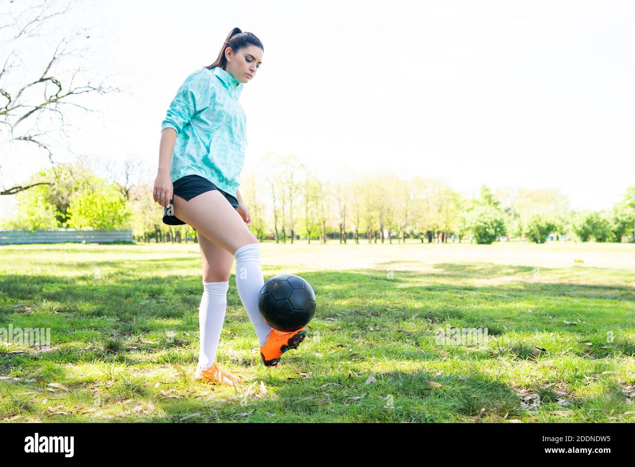 Junge Frau übt Fußball mit Ball. Stockfoto