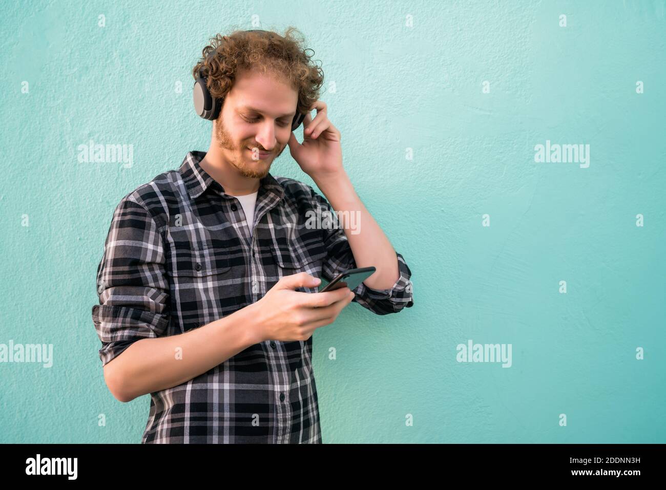 Mann hört Musik mit Kopfhörern und Handy. Stockfoto