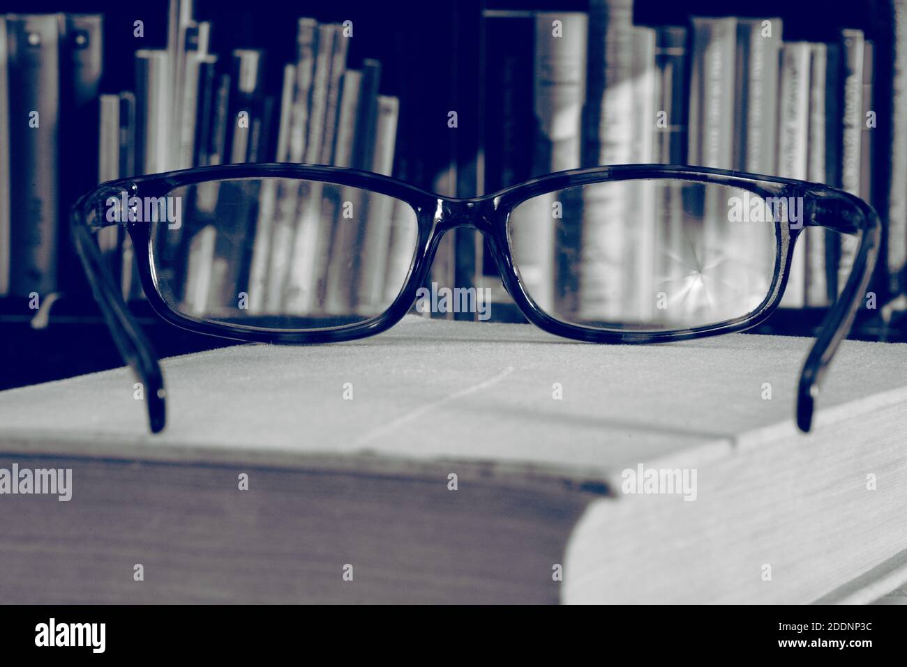 Gläser, ein Buch und eine Bibliothek Stockfoto