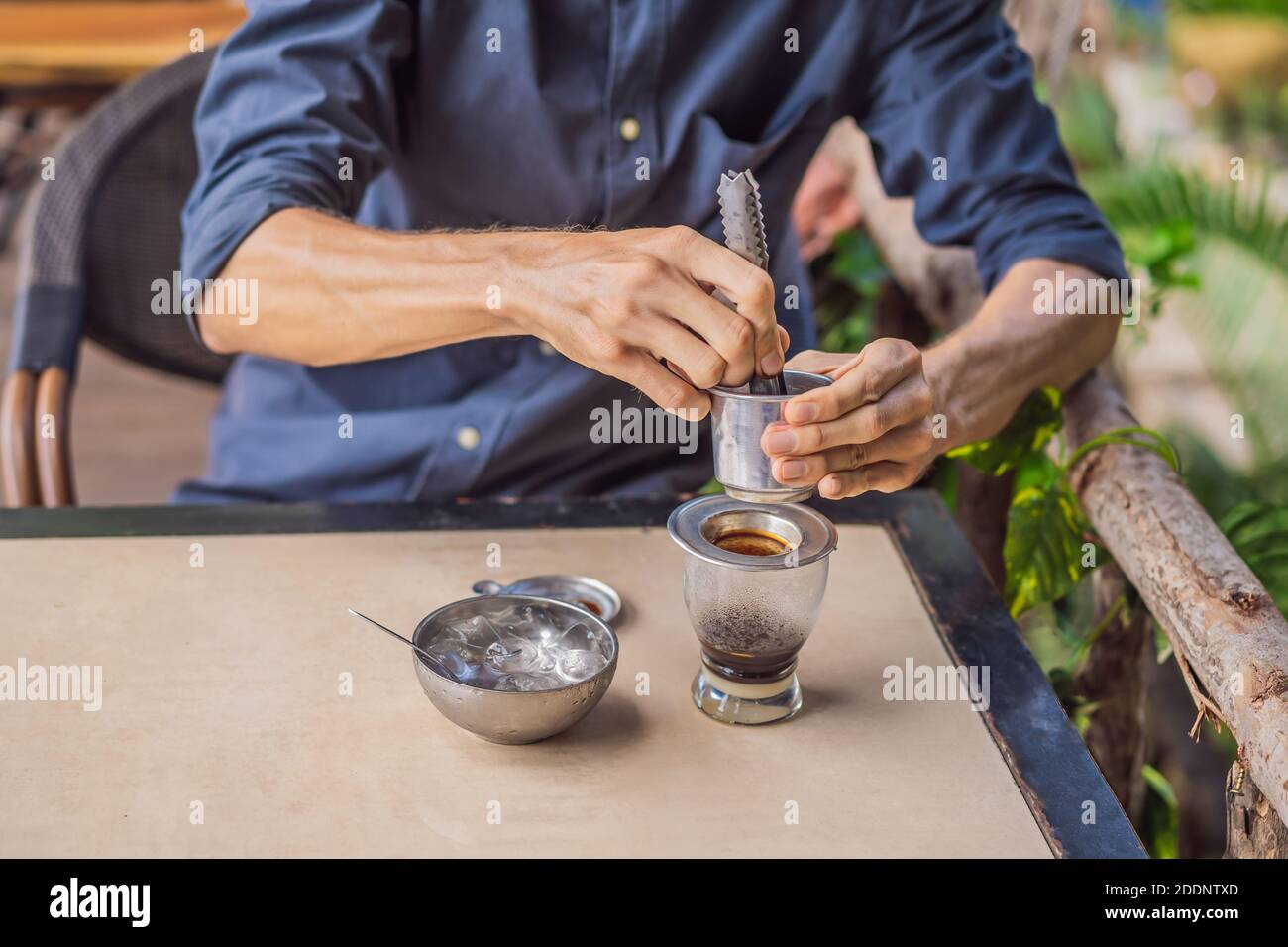 Kaukasischen Mann und traditionelle Tropfen gebrühten vietnamesischen Kaffee aus phinfilter Stockfoto