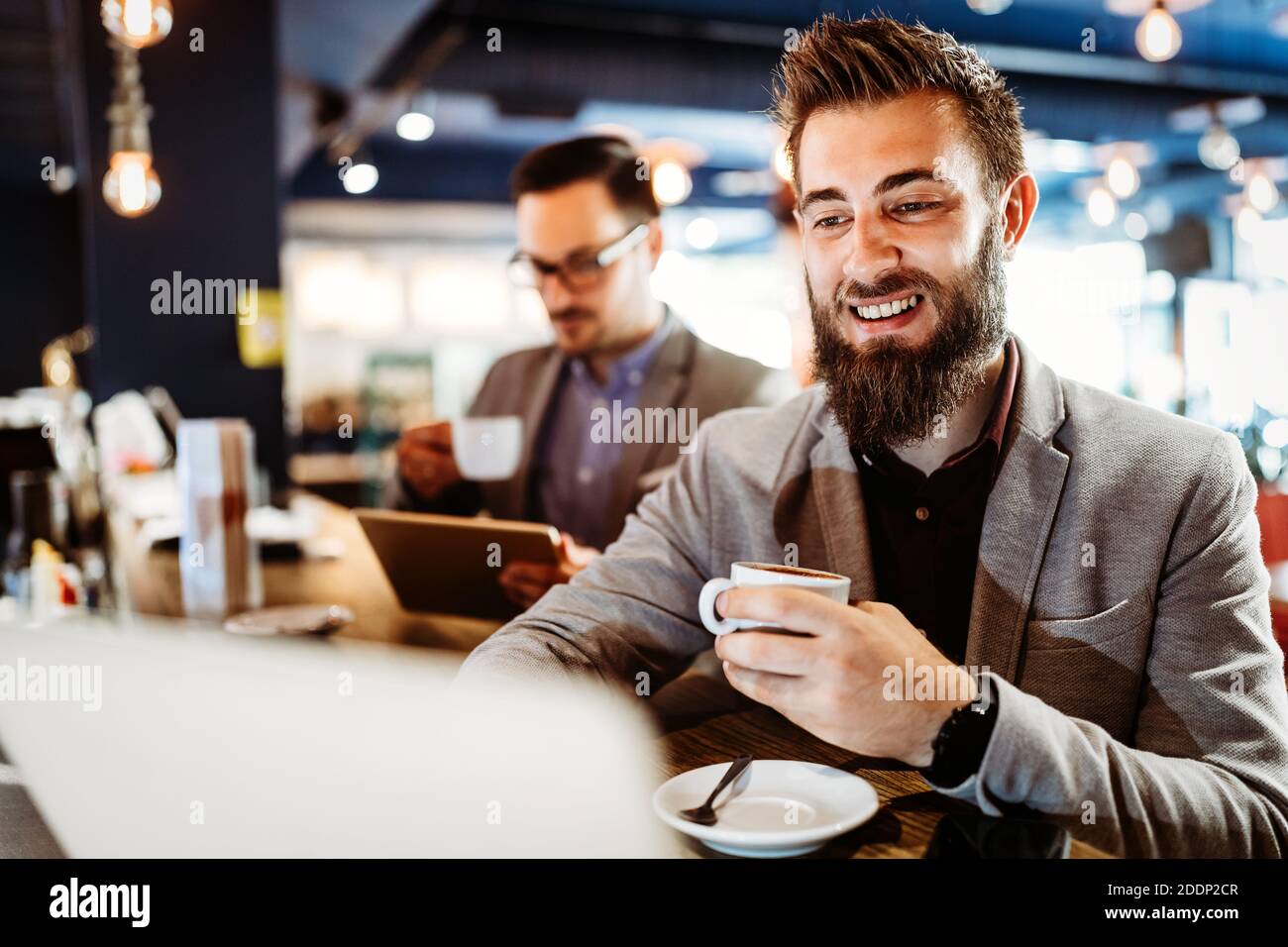 Fröhliche Geschäftsleute mit Laptop bei der Sitzung Stockfoto