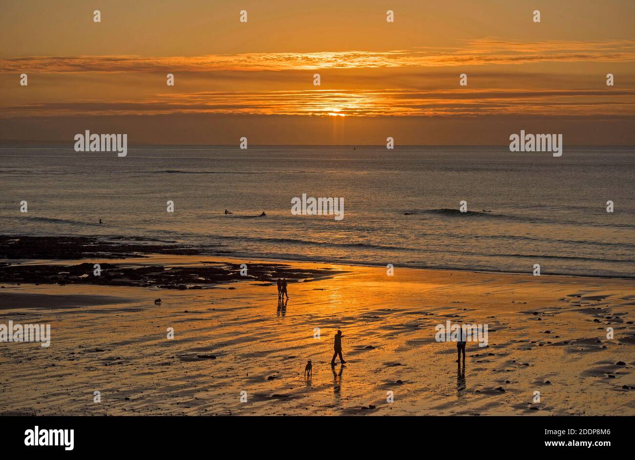 Swansea, Großbritannien. November 2020. Leute gehen am Strand spazieren, während die Sonne über Langland Bay in der Nähe von Swansea an einem kalten und frostigen Herbstmorgen aufgeht. Quelle: Phil Rees/Alamy Live News Stockfoto