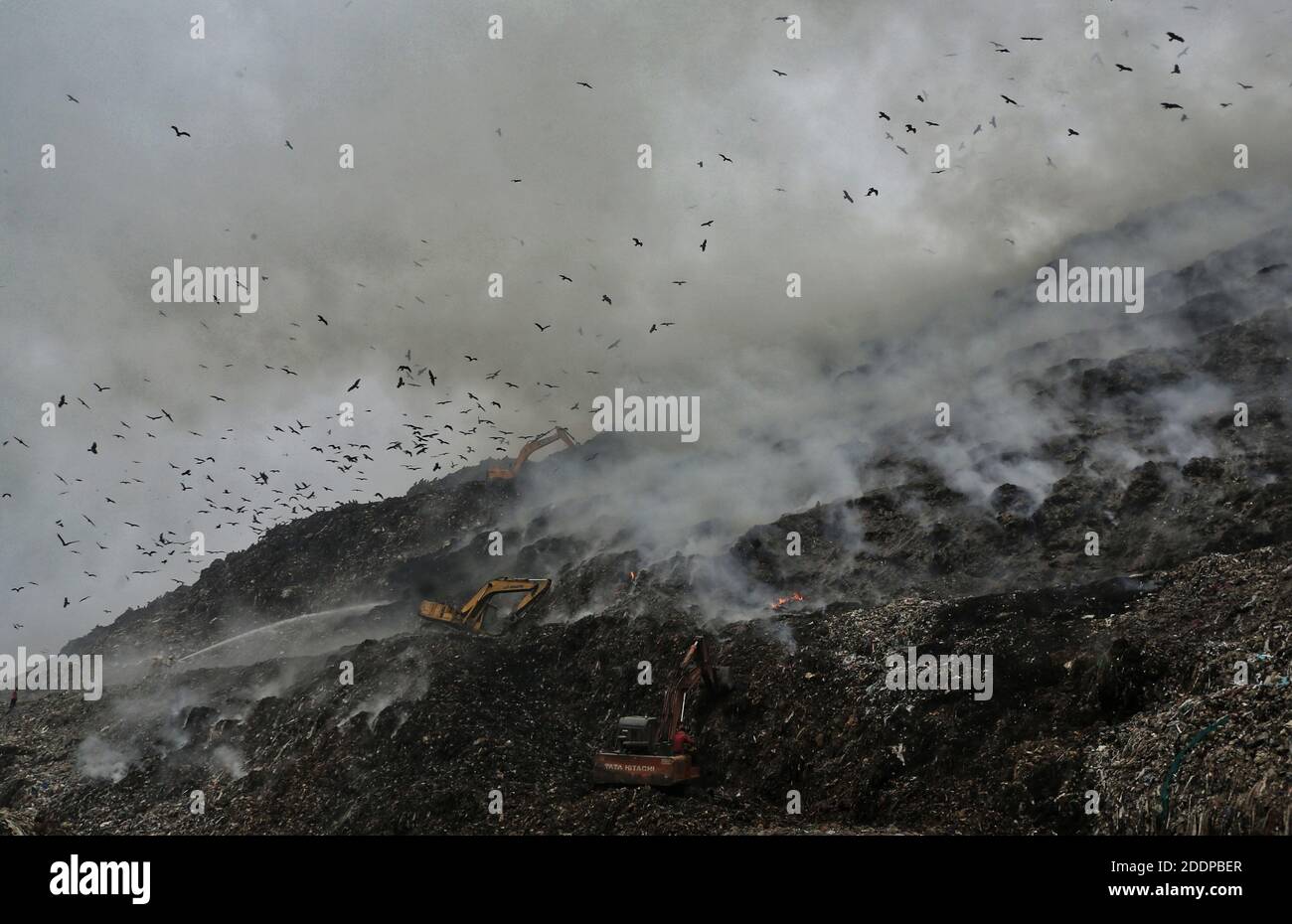 Buldozer, die daran arbeiteten, große Müllblöcke als riesige Rauchwolke vom Berg der Mülldeponie in Ghazipur zu verlagern, nachdem ein Feuer auf der größten Mülldeponie ausbrach, als Neu-Delhi nach Luft schnappte und die Luftqualität insgesamt in eine schwere Kategorie rutschte. Foto: Sondeep Shankar Stockfoto