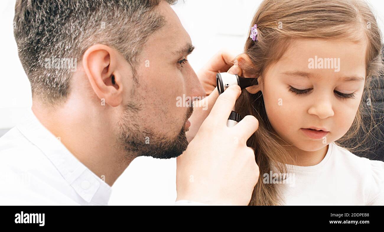 Otolaryngologe, der das Ohr des Kindes mit einem Otoskop überprüft. Höruntersuchung für kleine Mädchen Nahaufnahme. Otitis media, Ohr Entzündung Stockfoto