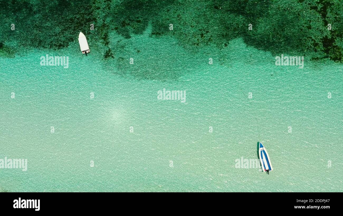 Meerwasseroberfläche mit Boot in Lagune, Copy space for Text. Draufsicht transparent türkis Meer Wasseroberfläche. Stockfoto
