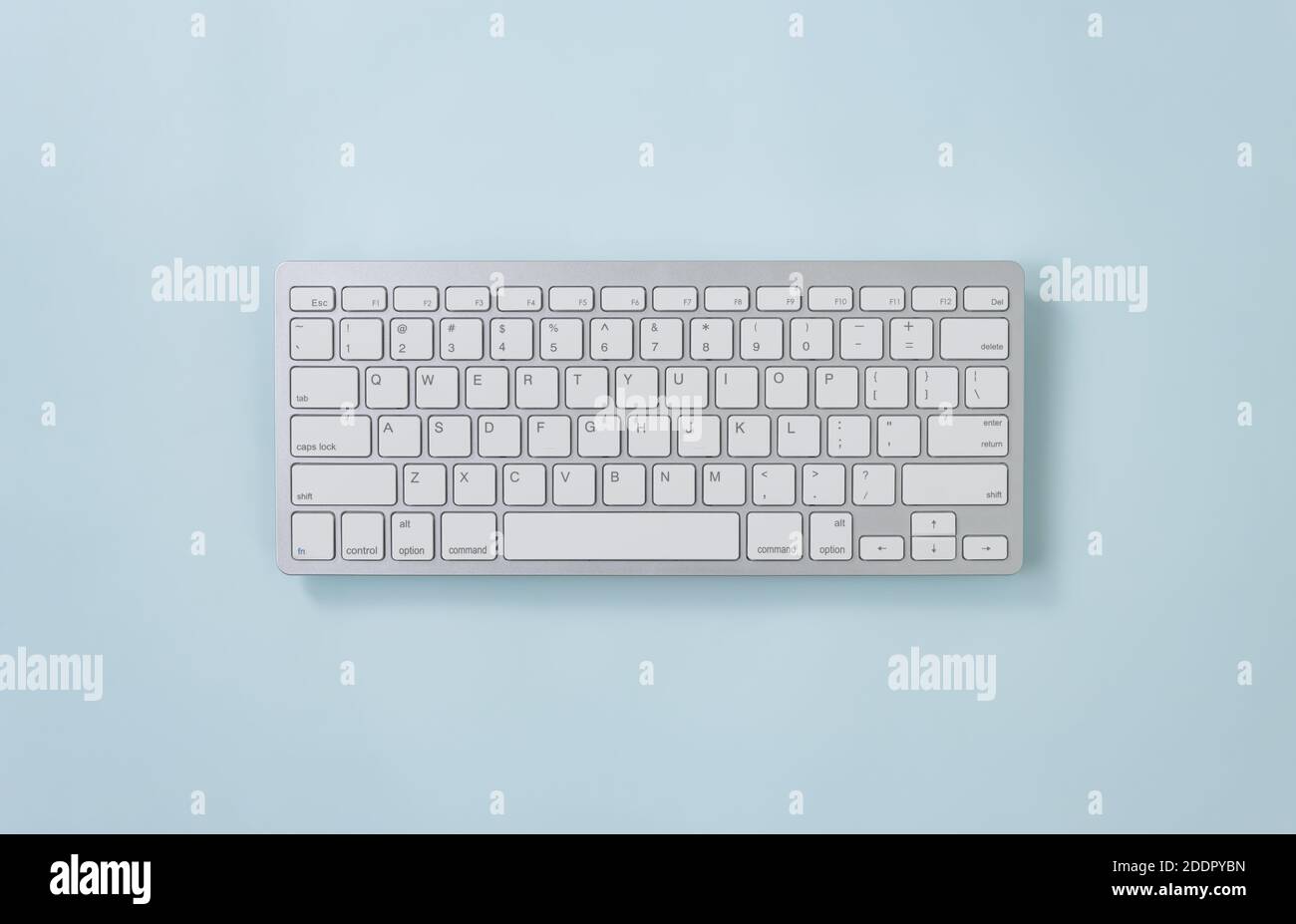 Tragbare Computer-Tastaturtasten oder Tastaturtaste in Weiß mit weitem Winkel Auf blauem Pastell minimalistischer Hintergrund am Mittelrahmen Stockfoto