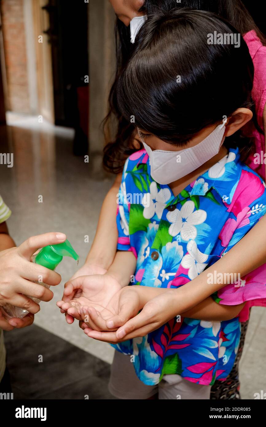 Südostasiatische Kinder mit flüssigem Gel-Händedesinfektionsmittel. Schutz vor infektiösen Viren Hygiene und gesunder Lebensstil. Stockfoto
