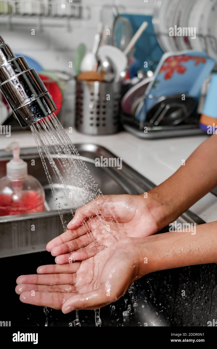 Nahaufnahme Bild der Hände unter Dusche von Wasser auf einer Spüle in der Küche gewaschen, um Sauberkeit und Gesundheit zu halten. Gesunder Lebensstil Stockfoto