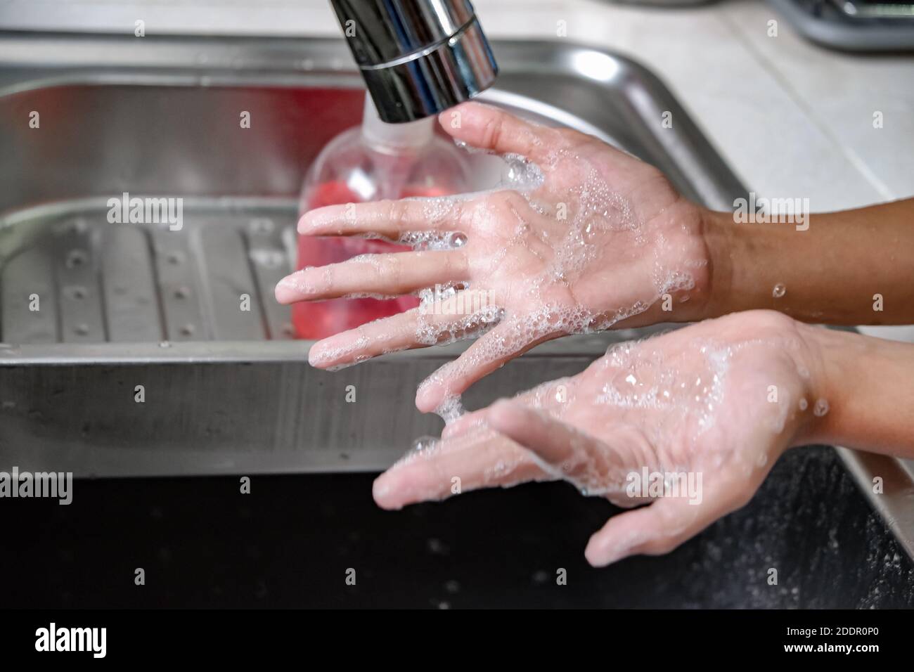Nahaufnahme Bild der Hände gewaschen mit Seife unter Wasser Dusche auf einem Spülbecken, um Hygiene und Gesundheit zu gewährleisten. Gesunder Lebensstil Stockfoto