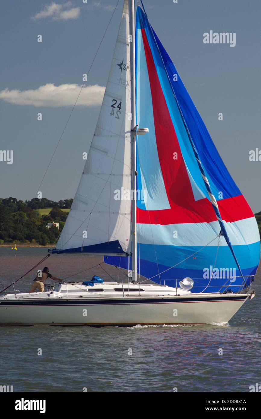 Bunte fliegende Jib auf einer kleinen Yacht's Segeln auf der exe Mündung von Turf Lock an einem sonnigen Herbsttag. Devon, Großbritannien Stockfoto