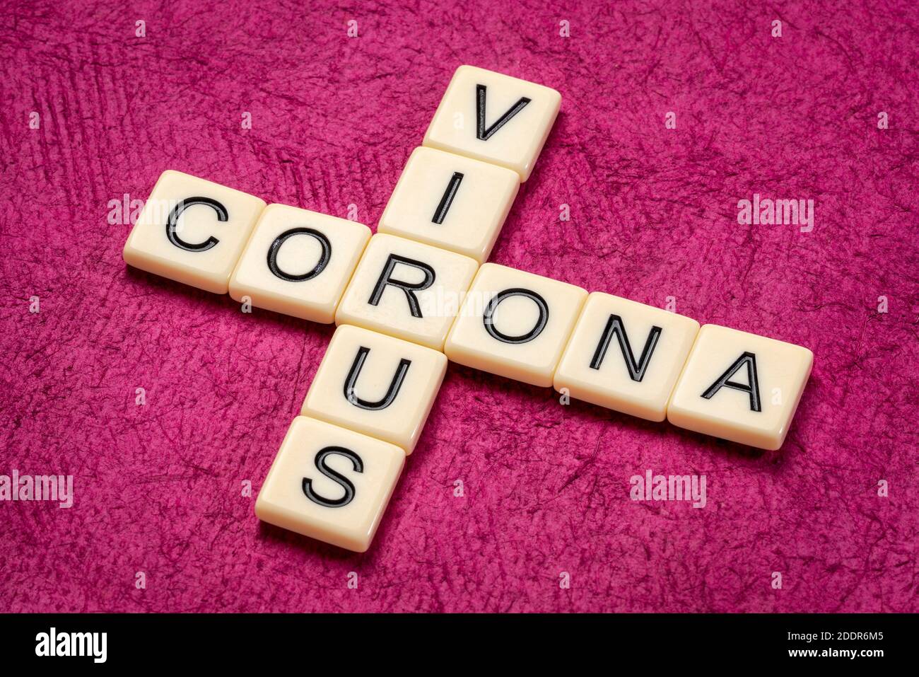Coronavirus Kreuzworträtsel in Elfenbein Buchstaben Fliesen gegen strukturierte handgemachte Papier, covid-19 Pandemie-Konzept Stockfoto