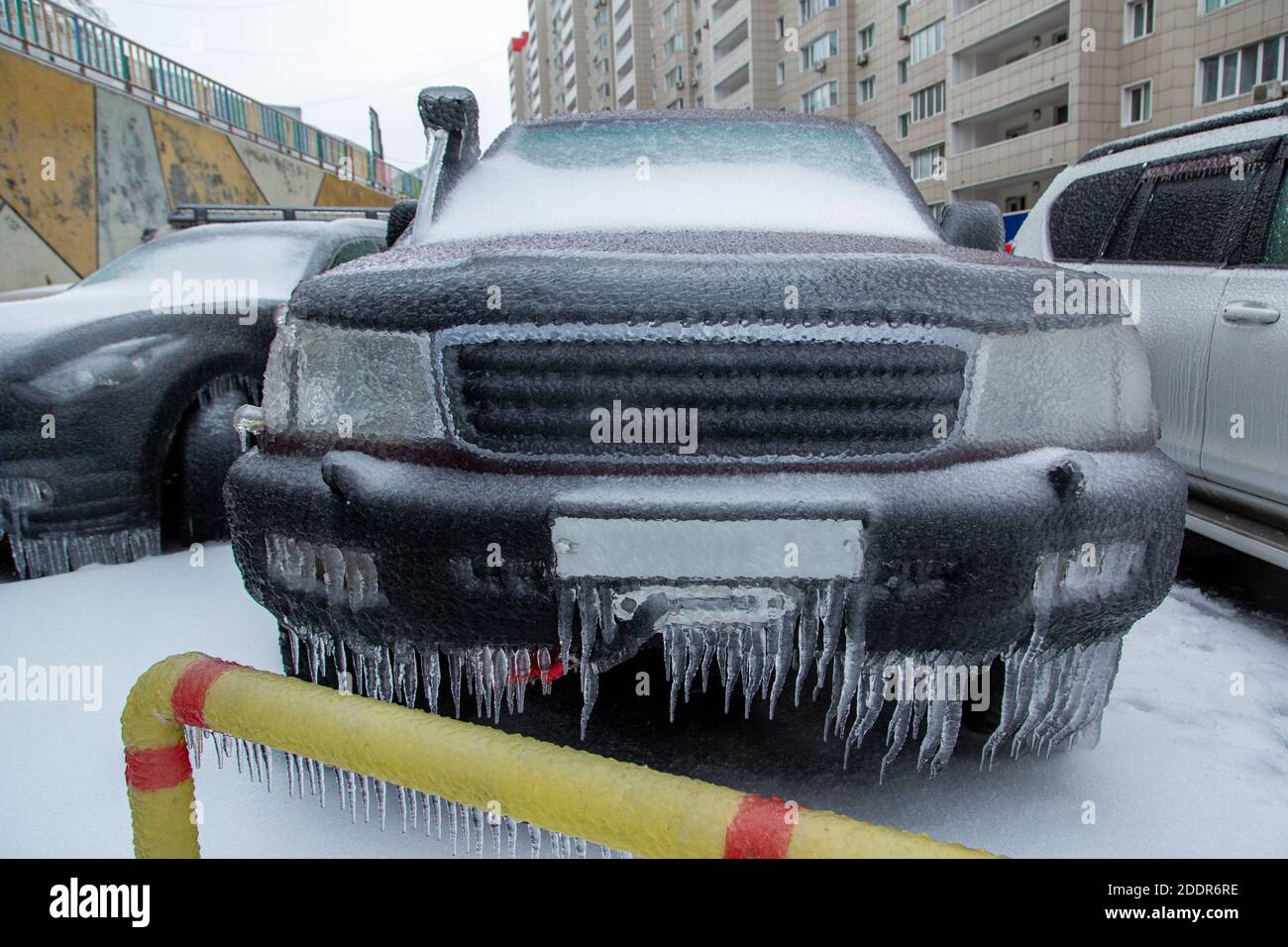 Der schwarze SUV ist eingefroren. Bedeckt mit einer Eiskruste nach dem Regen im Winter. Stockfoto