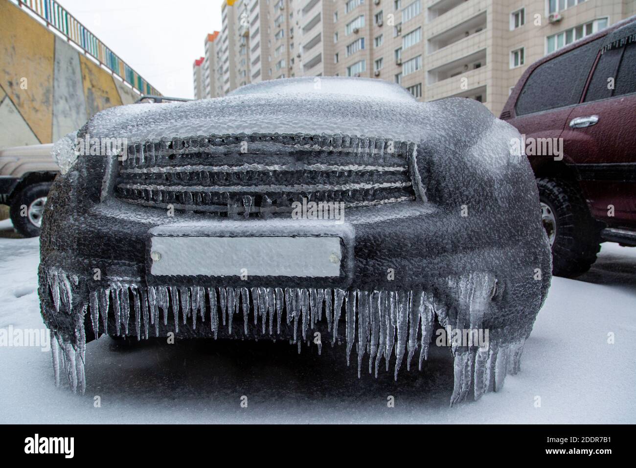 Der schwarze SUV ist eingefroren. Bedeckt mit einer Eiskruste nach dem Regen im Winter. Stockfoto